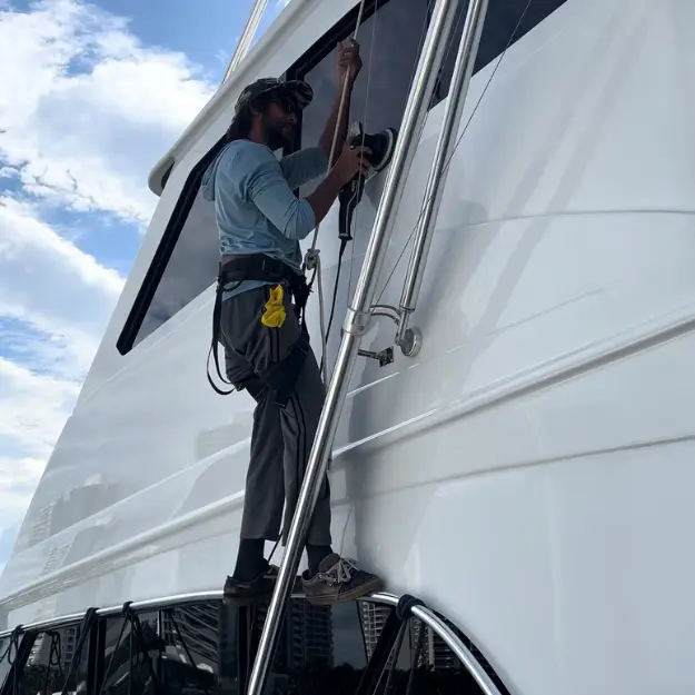 Global Yacht Detailing technician polishing a yacht hull side